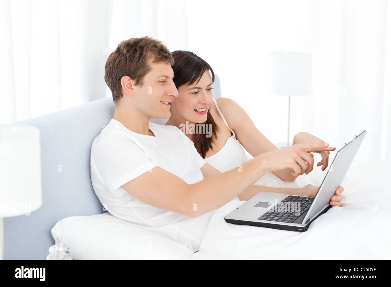 Young couple watching videos on their computer at home Stock Photo - Alamy