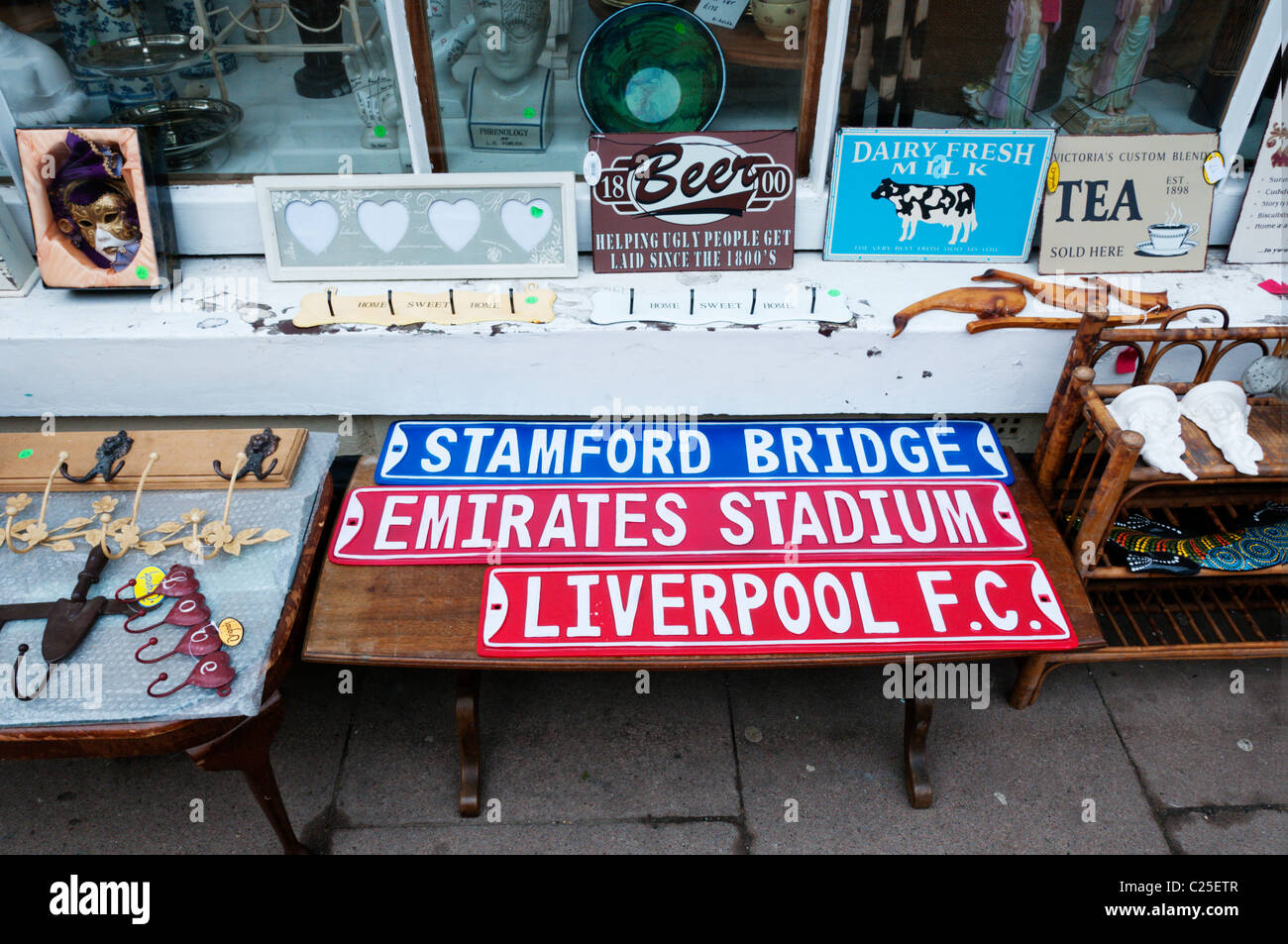 Reproduction football ground nameplates for sale as souvenirs together with old advertising signs in a junk shop Stock Photo