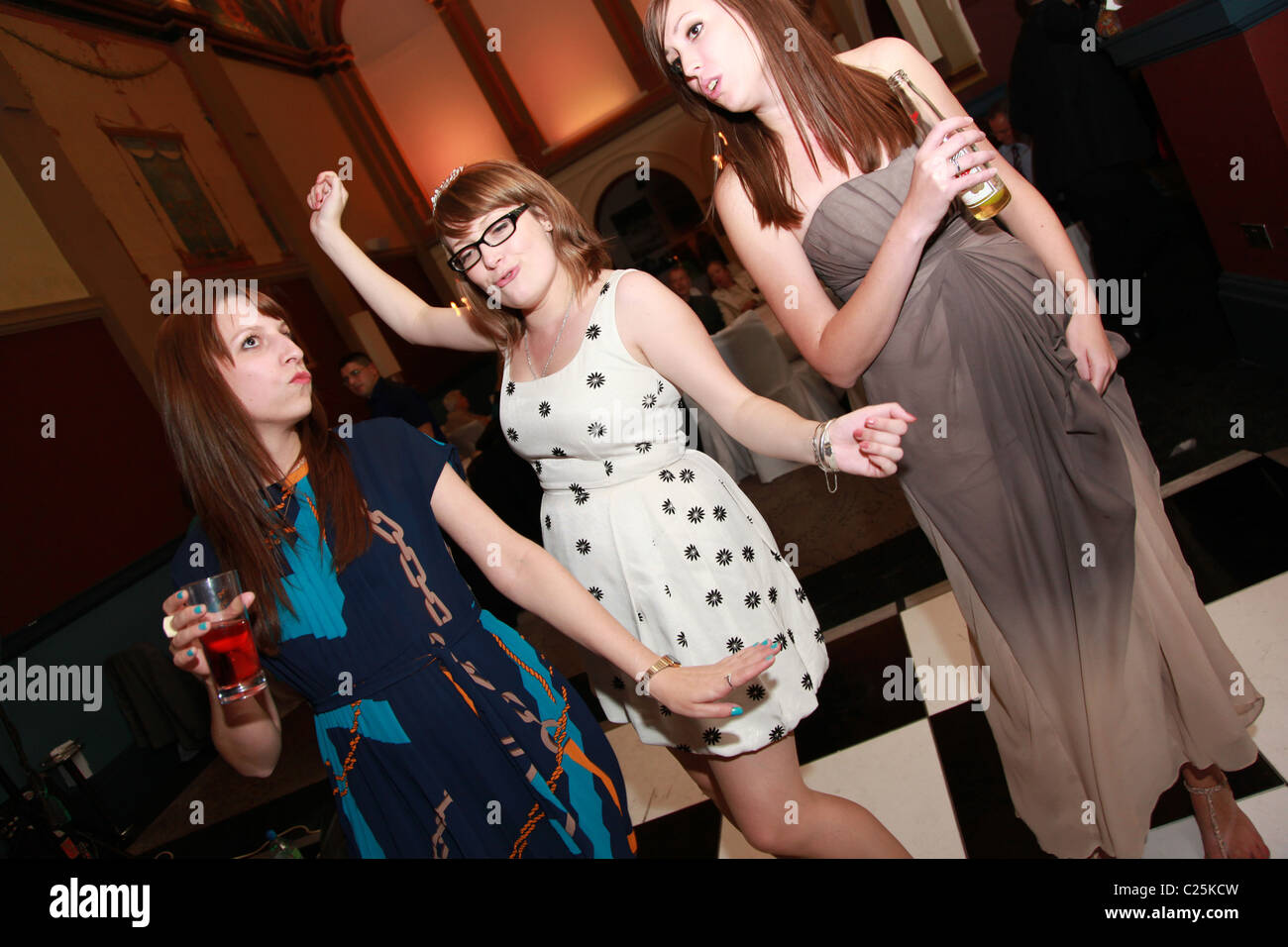 Young girls drinking and dancing at a party. Stock Photo