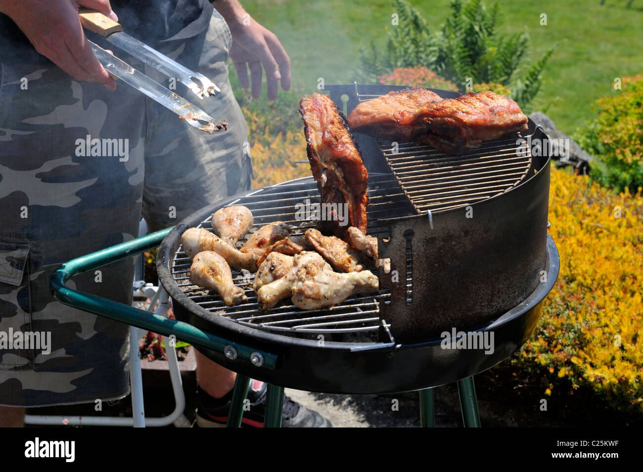 Cooking chicken and ribs on barbecue Stock Photo