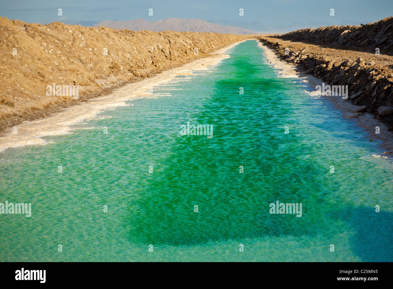 Green canals of liquid Calcium Chloride drying in the desert outside