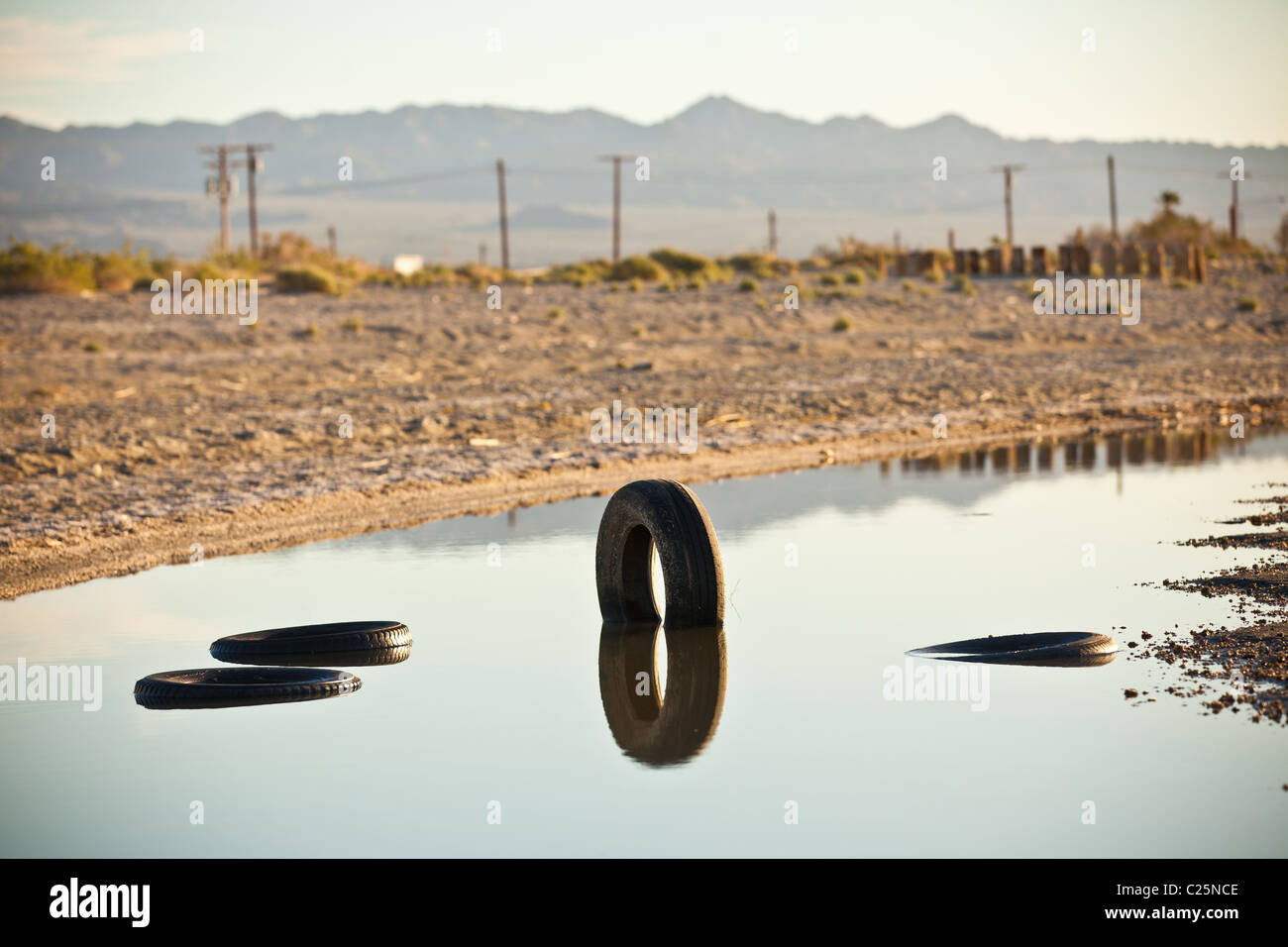 Tires and other trash litter the coast of the Salton Sea at sunrise Imperial Valley, CA. Stock Photo