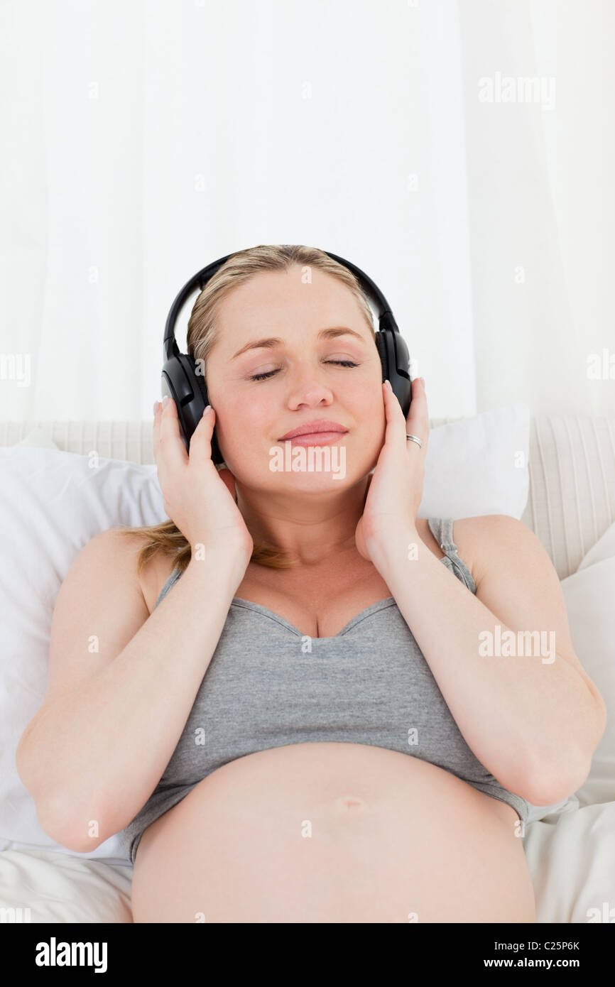 Lovely pregnant woman listening to music on her bed Stock Photo - Alamy