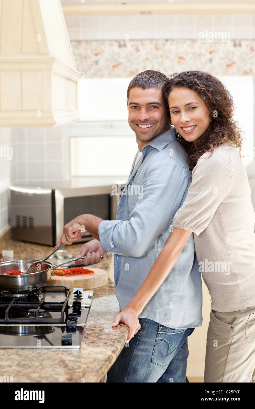 Woman hugging her husband while he is cooking Stock Photo - Alamy