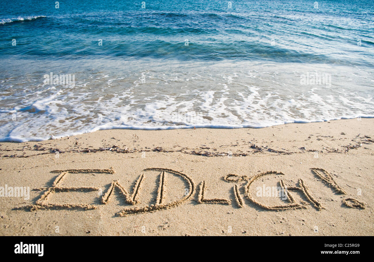 The german word 'Endlich' written in the Sand Stock Photo