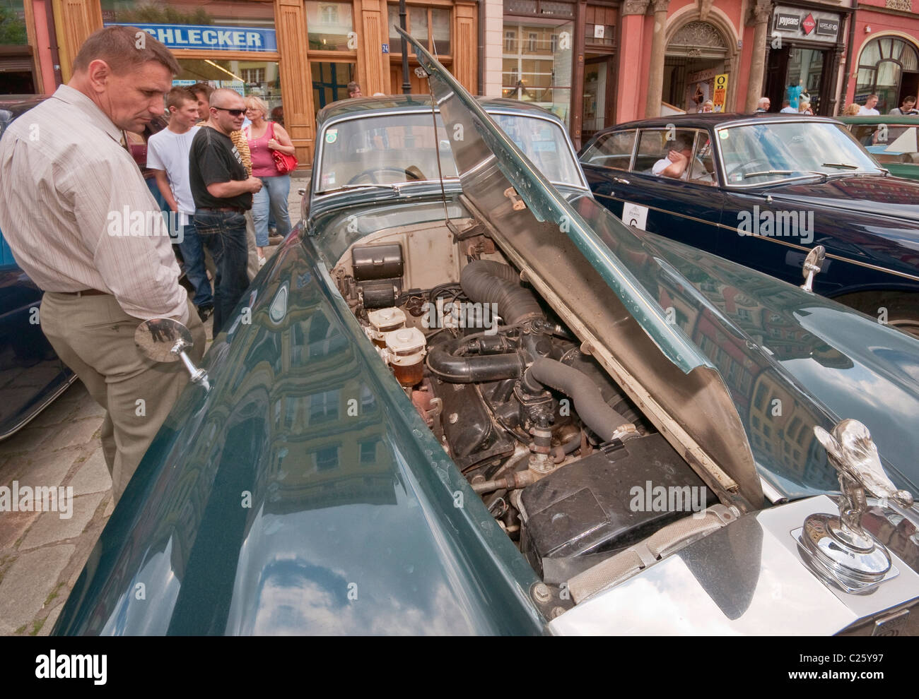 Man looking under the hood of a vintage car at Rolls-Royce & Bentley Club meeting at Rynek in Świdnica, Lower Silesia, Poland Stock Photo