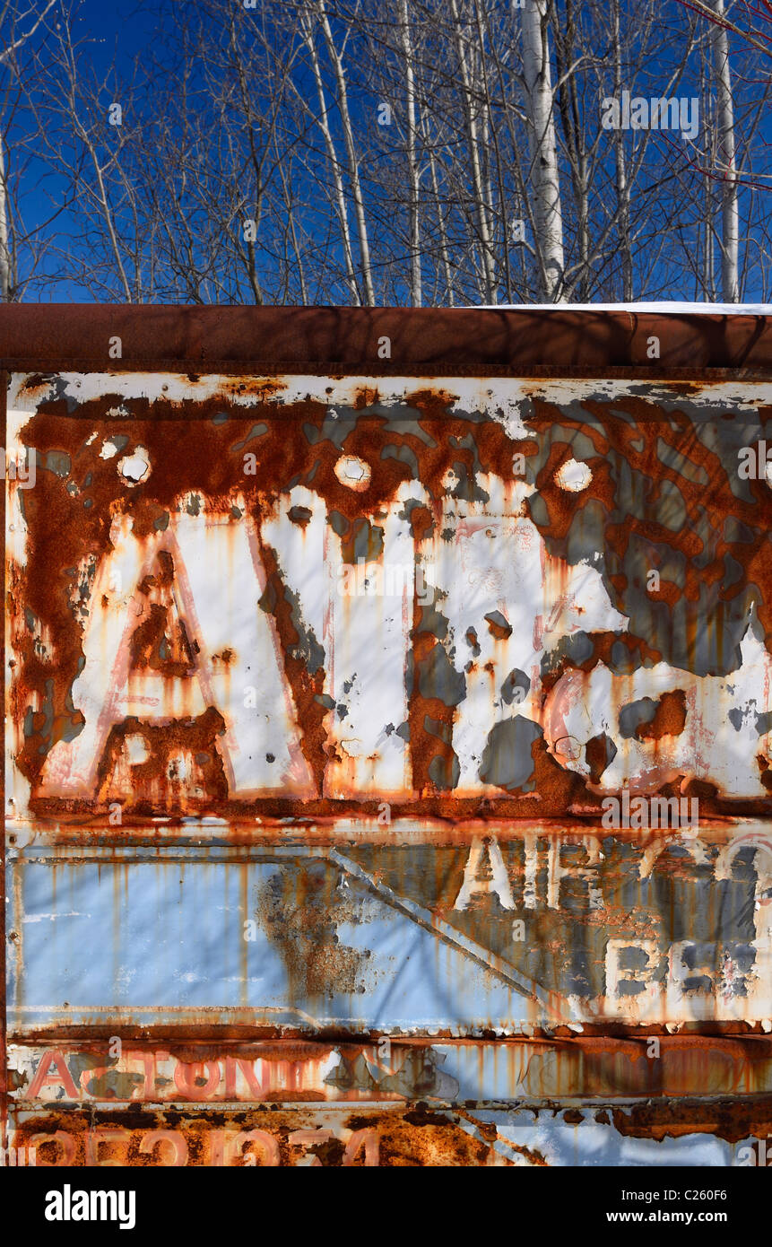 Flaking paint on an rusting abandoned Air Conditioning service truck in a forest Stock Photo
