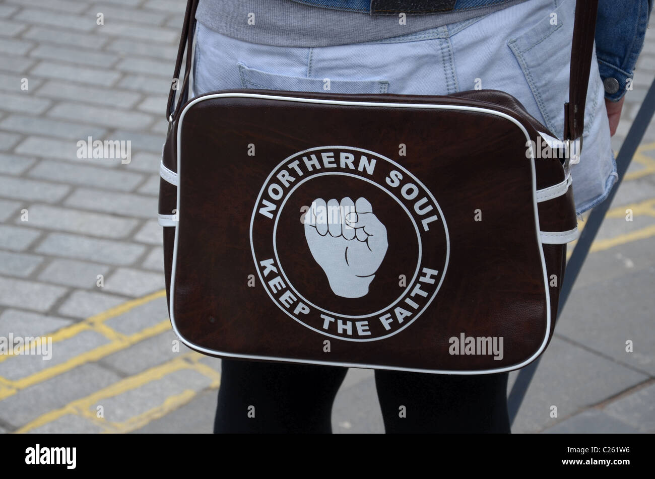 Girl carrying a 'Northern Soul, Keep The Faith' holdall in Edinburgh Stock Photo
