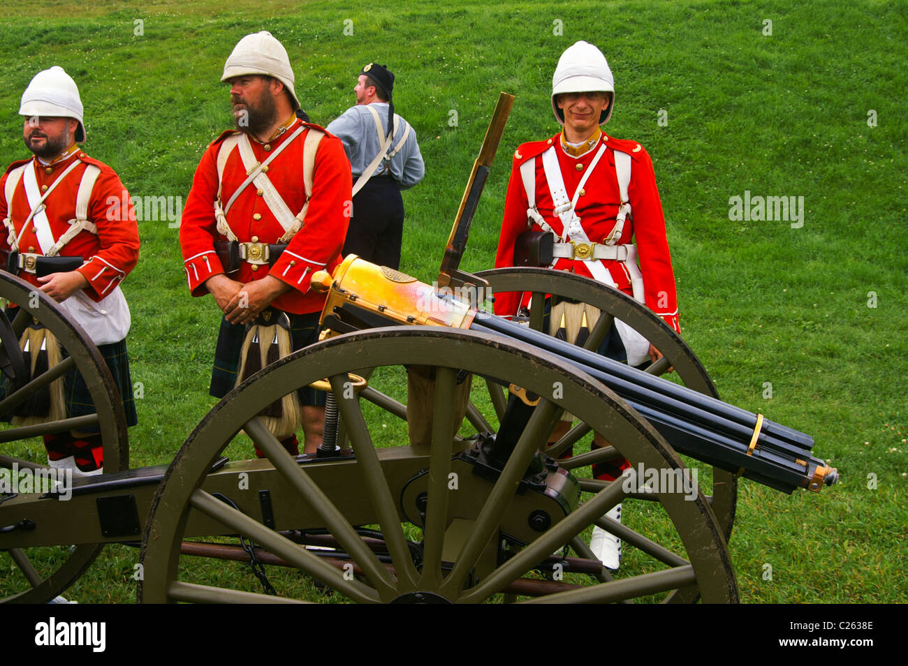 Men wearing the uniforms of The Gordon Highlanders with a replica Colt Gatling gun during a historical reenactment. Stock Photo