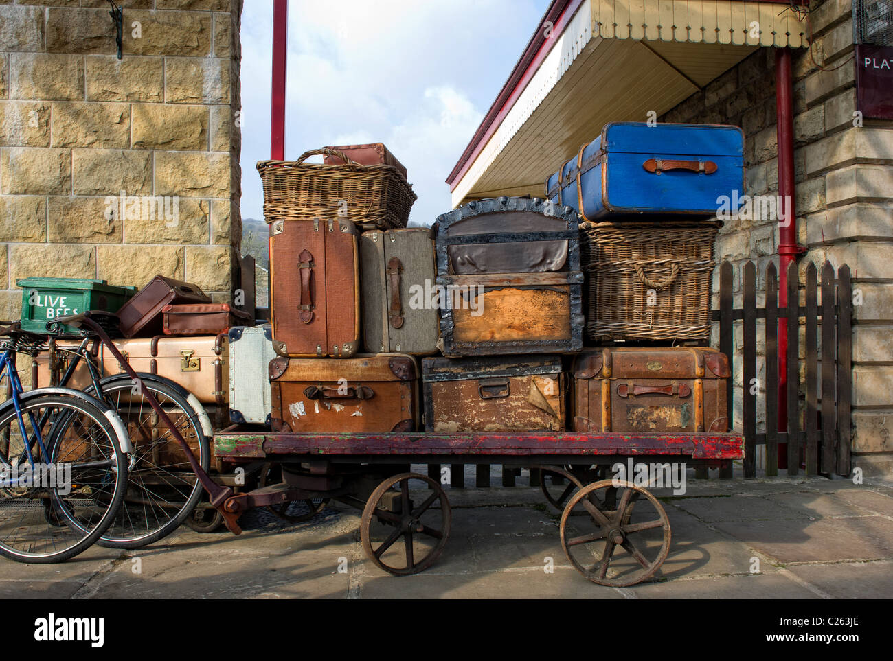 Old suitcases  and wicker baskets on a luggage trolley at Ramsbottom Railway Station on the East Lancs Railway Stock Photo