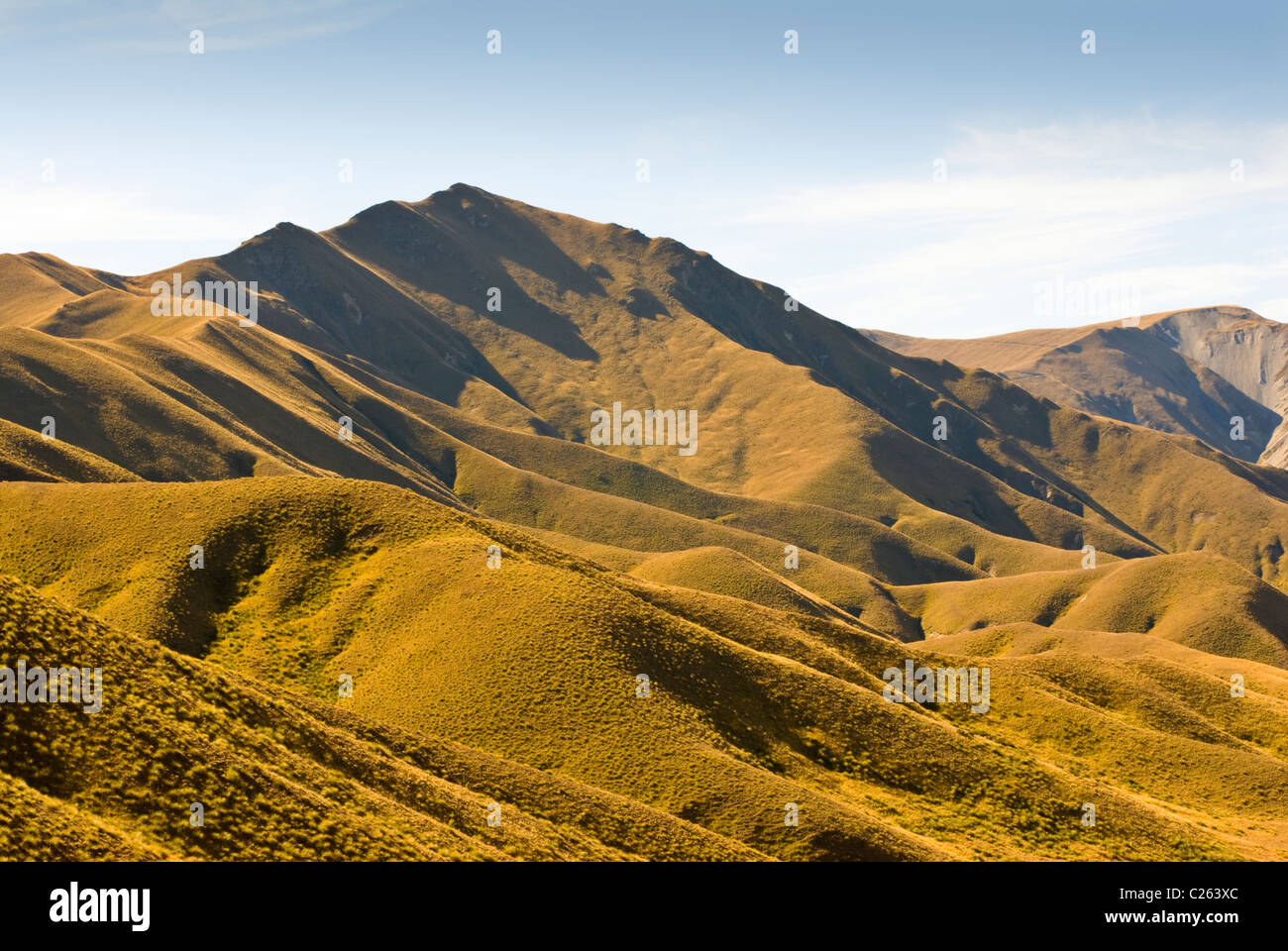 The hills surrounding Lindis Pass in the afternoon light New Zealands MacKenzie Country Stock Photo