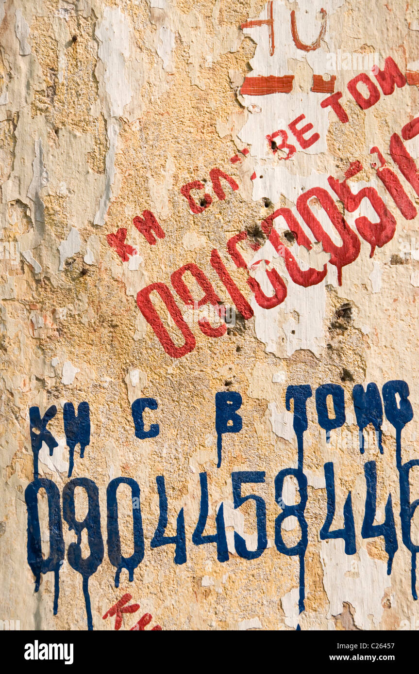 Advertisements stenciled on a wall in Hanoi, Vietnam Stock Photo