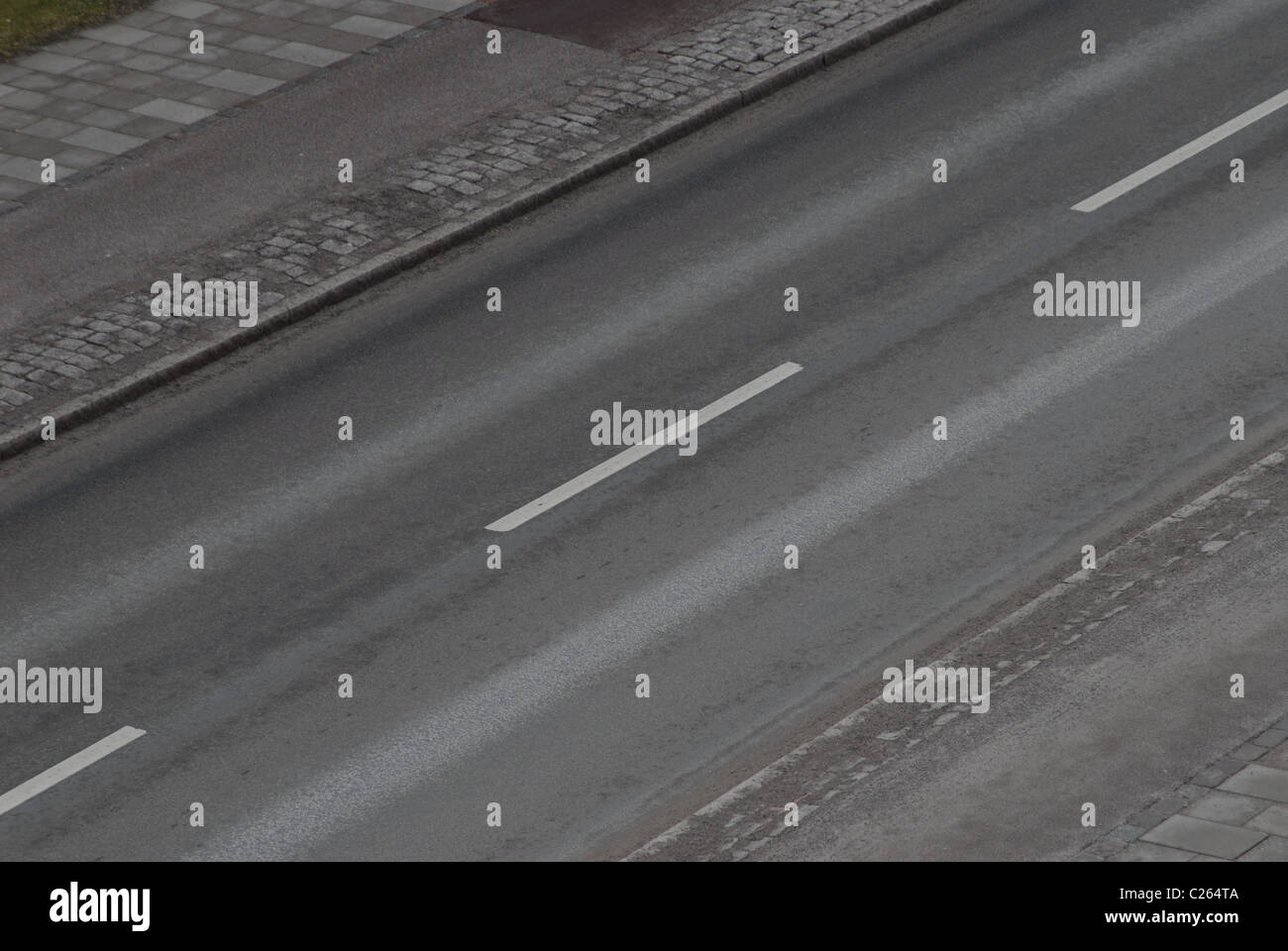 Diagonal road with white lines and various types of surfaces. Stock Photo