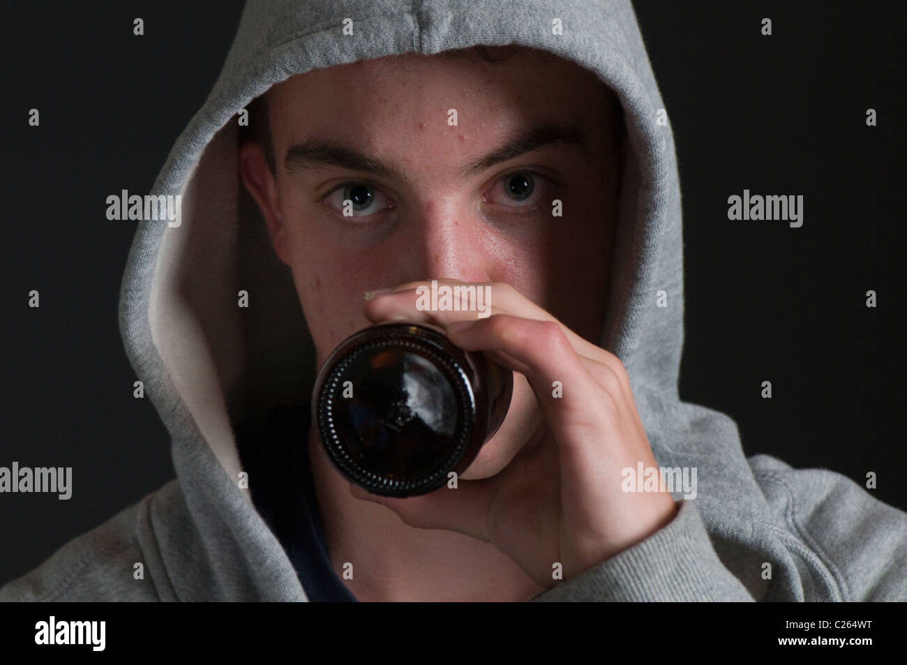 Spotty teenage hoody drinking beer Stock Photo