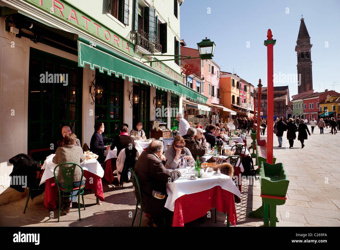 people eating and drinking at an outdoor restaurant, Burano village, Venice, Italy Stock Photo