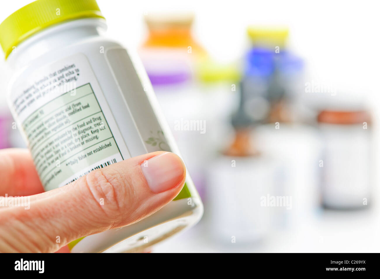 Hand holding medicine bottle to read label Stock Photo