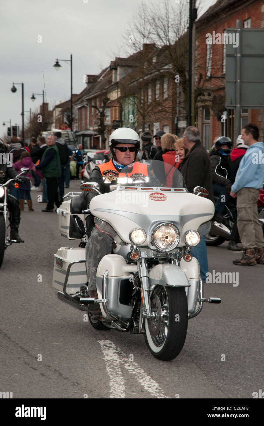 Harley Davidson motorcyclist rides his bike along Wootton Bassett High Street to raise funds in the Ride of Respect parade Stock Photo