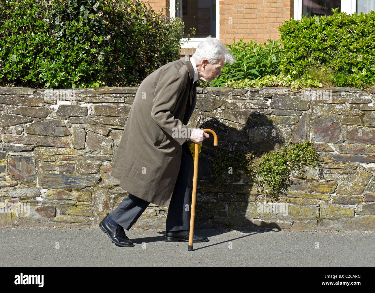 An old man using a walking stick Stock Photo