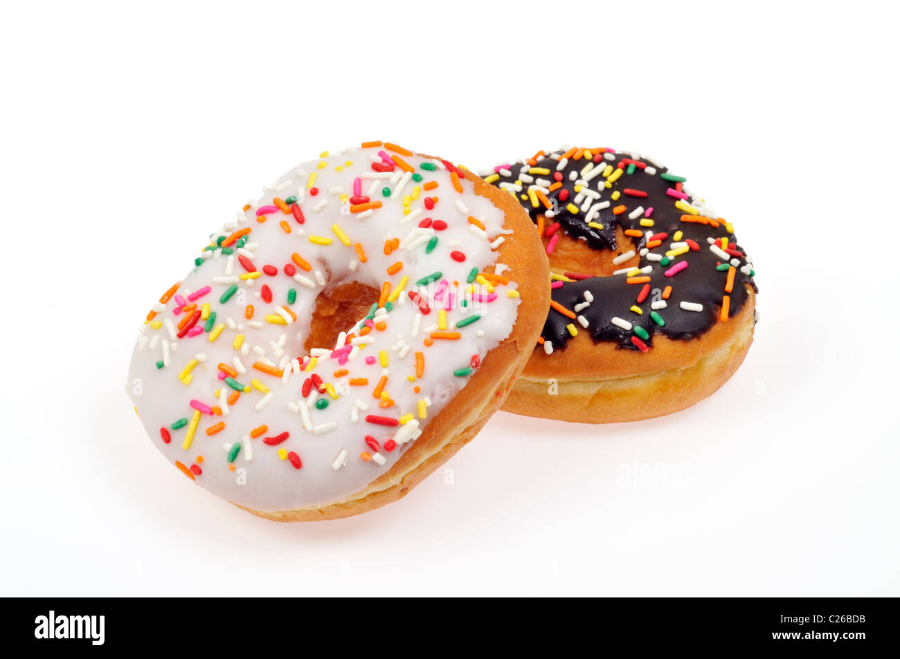Vanilla frosted donut and chocolate frosted doughnut with colorful sprinkles on white background, cut out. Stock Photo