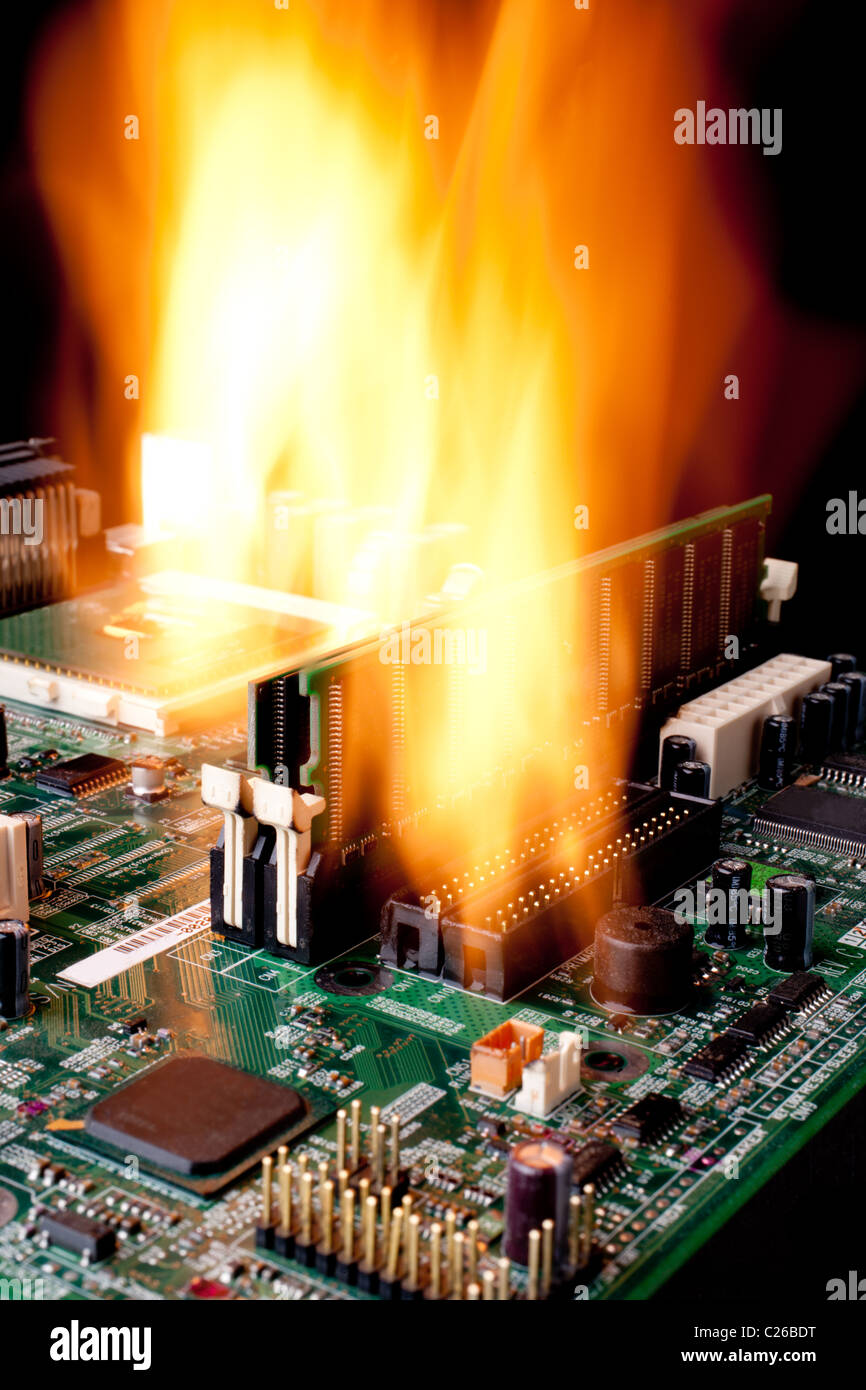 Vertical image of a computer electronic mother board on fire Stock Photo