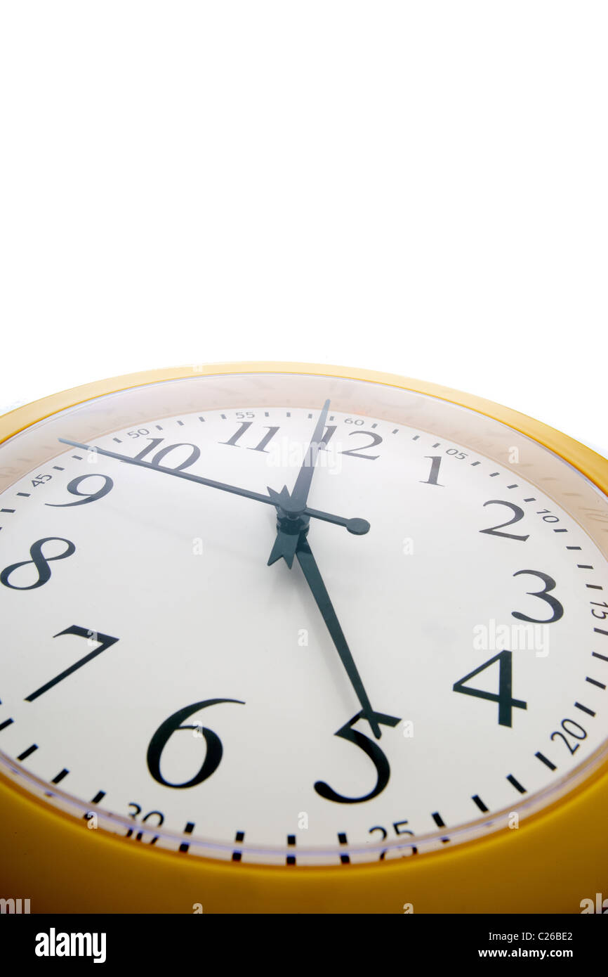 Wide angle close up of an analog clock just before the end of the workday at 5 pm Stock Photo