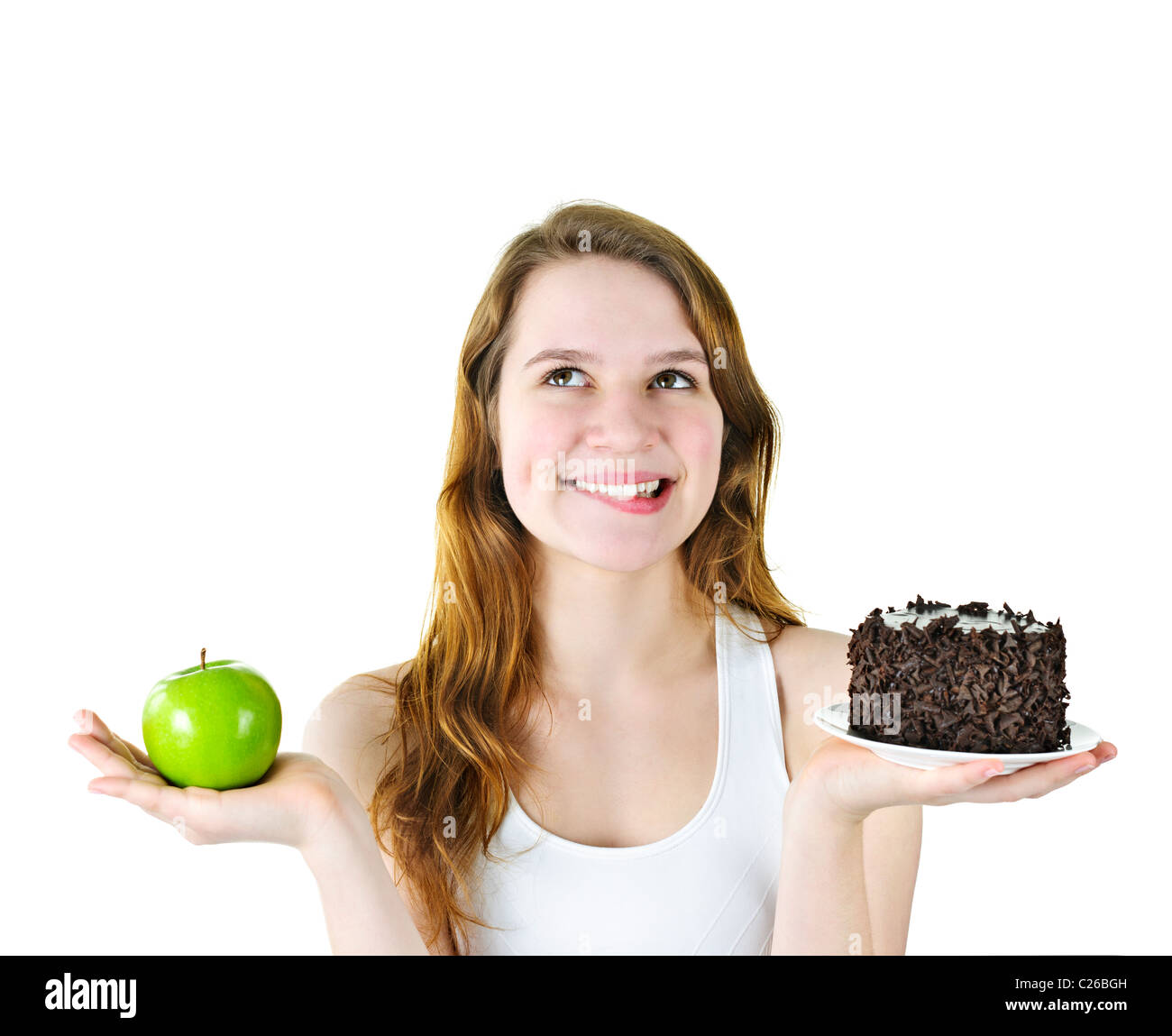 Tempted young woman holding apple and chocolate cake making a choice Stock Photo