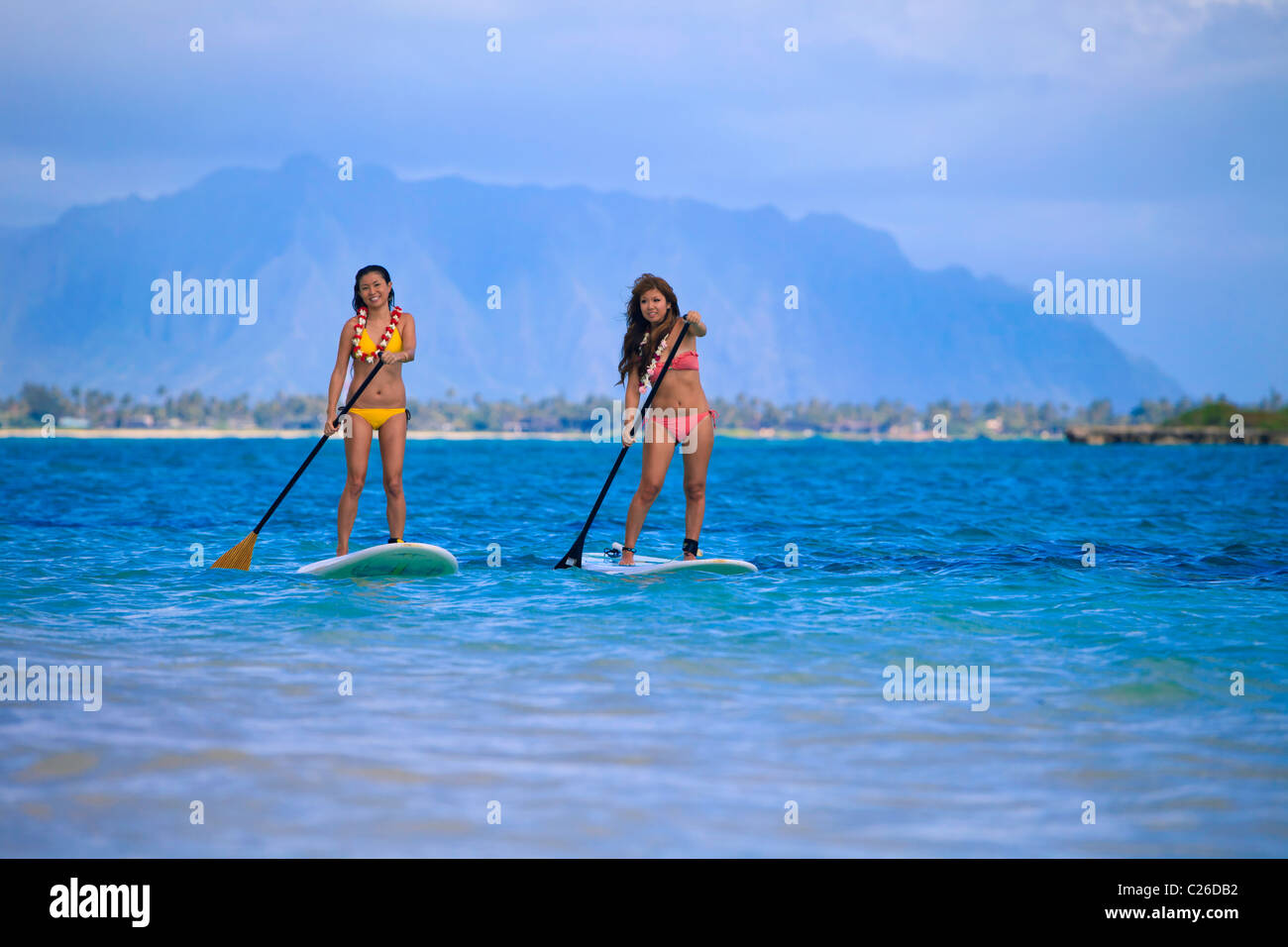 young japanese women in bikinis with their paddle boards in Hawaii