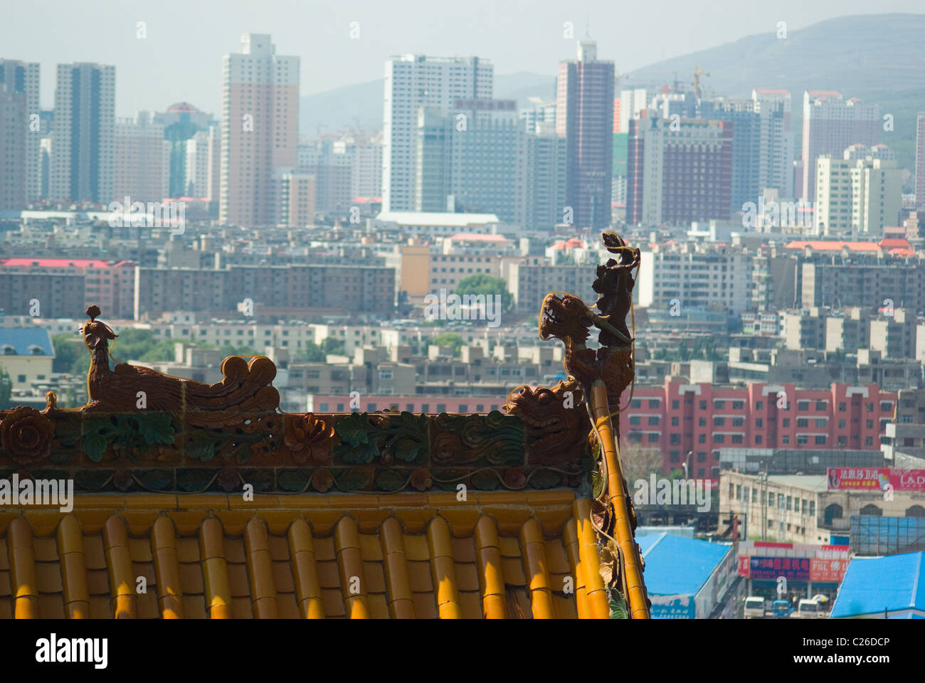 Old Chinese temple roof in front of skyscrapers a megalopolis city of Xining Stock Photo