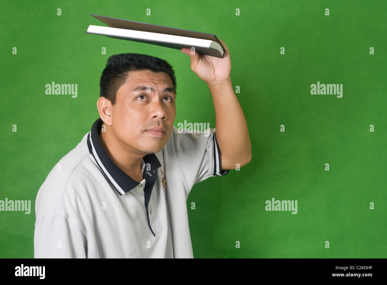 a man to protect the head with a book Stock Photo