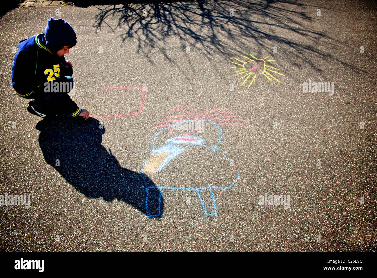 BOY DRAWING ON ASPHALT Stock Photo - Alamy