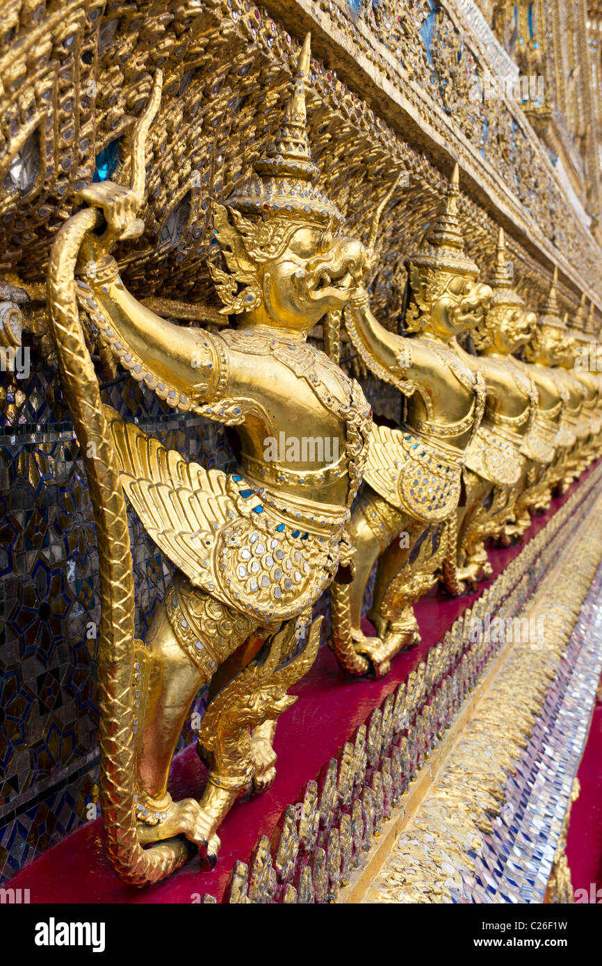 Row of Gold Garudas on the Exterior Wall of Wat Phra Kaew, or Temple of the Emerald Buddha at the Grand Palace Complex in Bangko Stock Photo