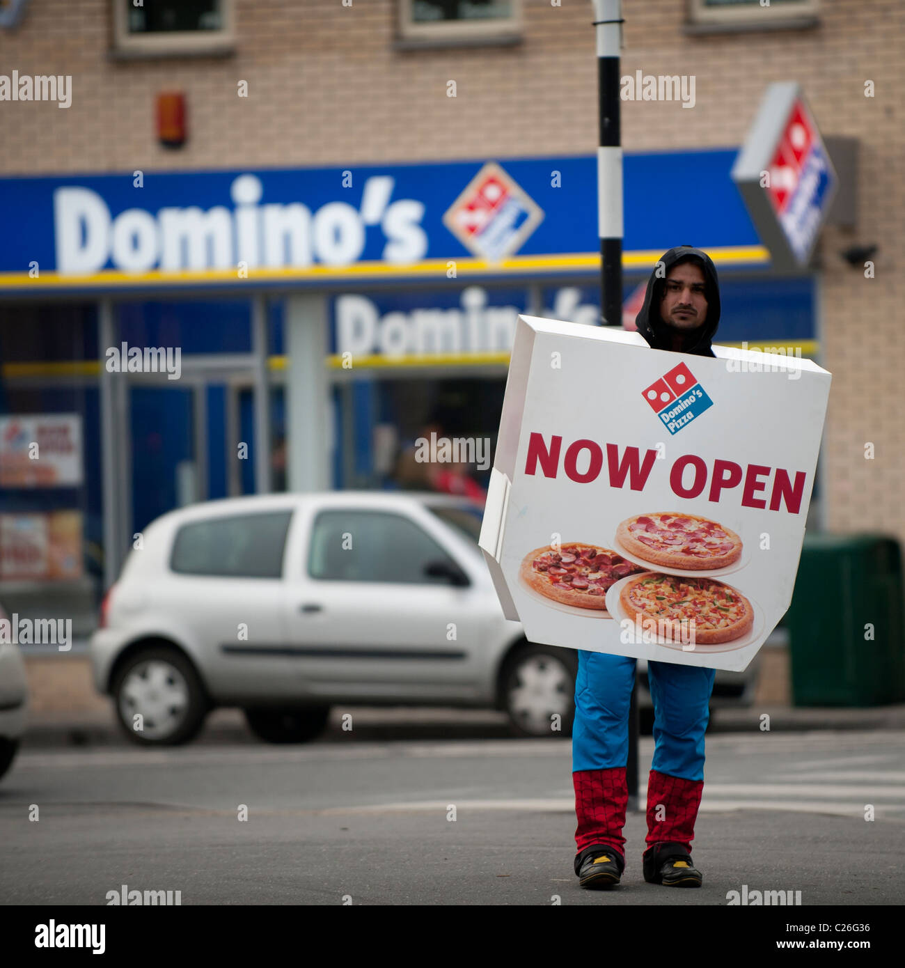 a-man-wearing-a-sandwich-board-promoting-a-new-dominos-pizza-franchise-C26G36.jpg