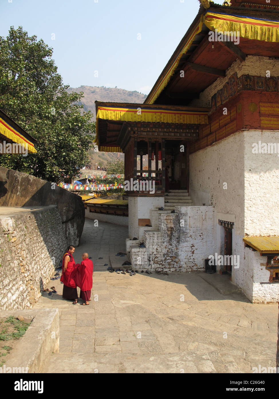 Two monks at the entrance of Gom Kora temple, a sacred meditation site of Guru Rimpoche, north of Trashigang, East Bhutan Stock Photo