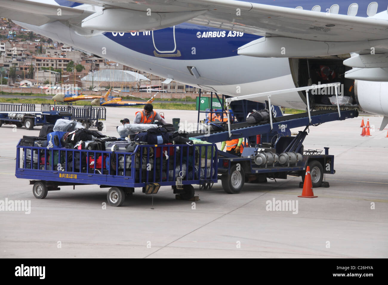 Baggage handlers at airport loading the luggage into the aircraft belly Stock Photo