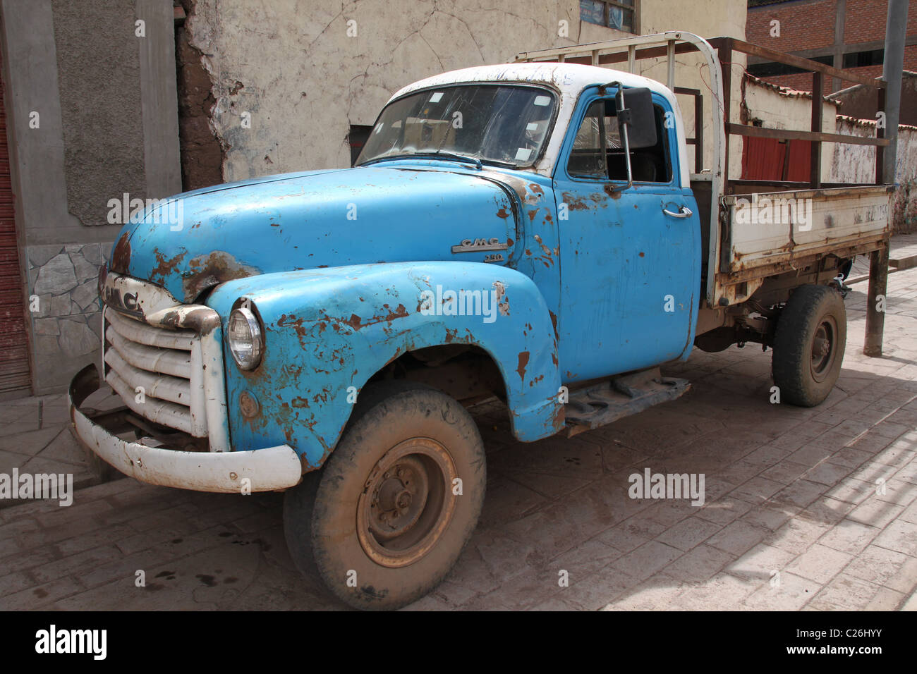 Rusty old blue pickup truck on a brick road. Stock Photo