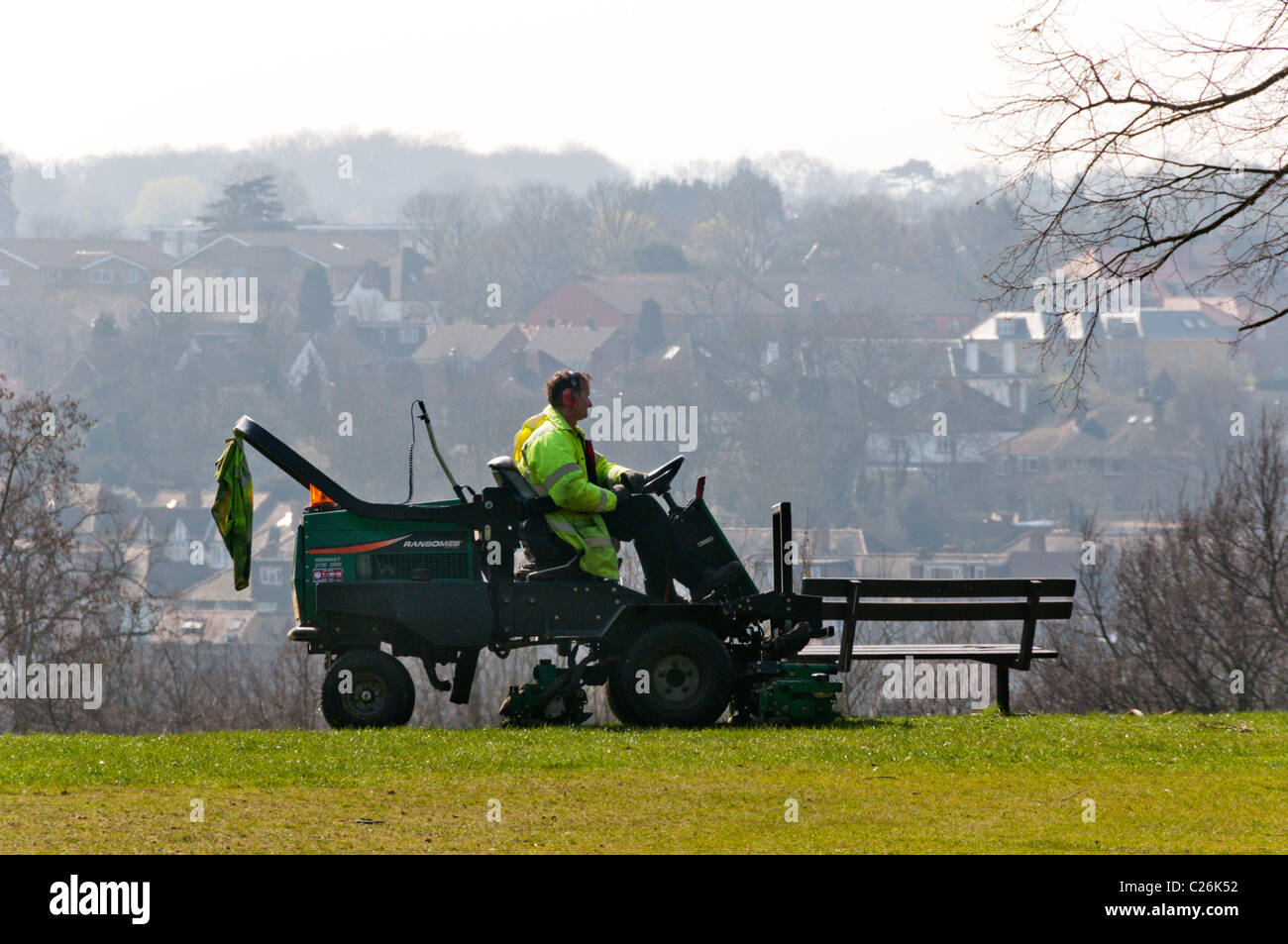 A gardener mows the grass in a public park in Bromley, Kent Stock Photo