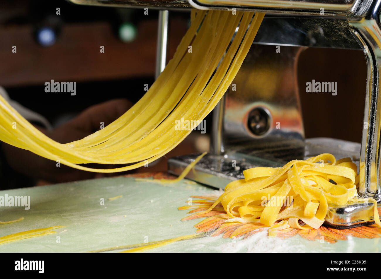 https://c8.alamy.com/comp/C26KB5/stock-photo-of-a-pasta-machine-rolling-out-tagliatelle-pasta-C26KB5.jpg