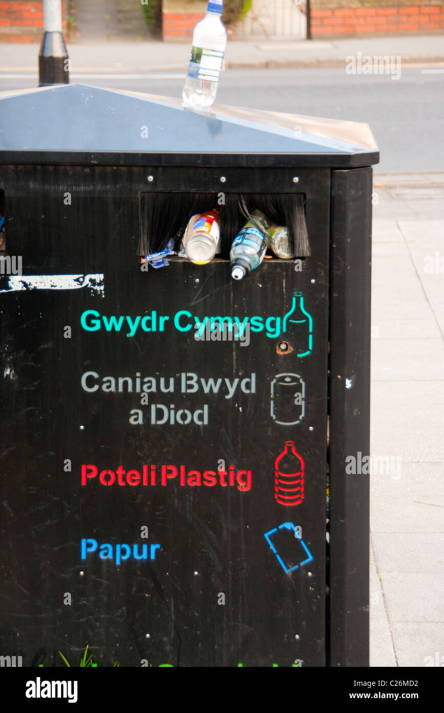 Recycling bin (full and overflowing) with list of items / instructions in Welsh language Cardiff South Wales UK Stock Photo