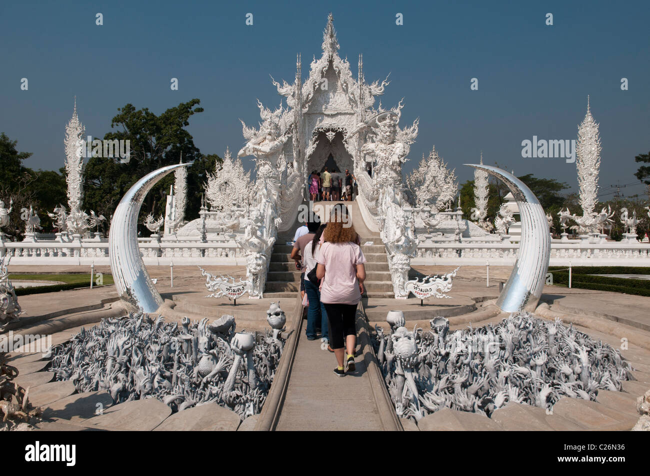 tourists entering the amazing white temple Wat Rong Khun in Chiang Rai, Thailand Stock Photo