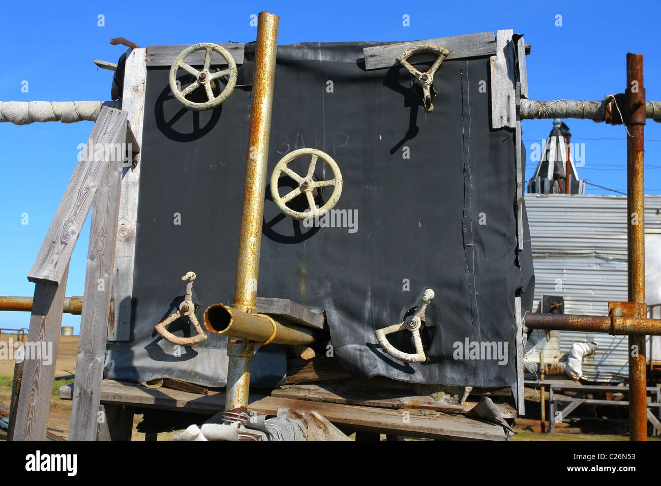 Five valve flywheels outside the wooden construction on the drillsite. Yamal, RUSSIA Stock Photo