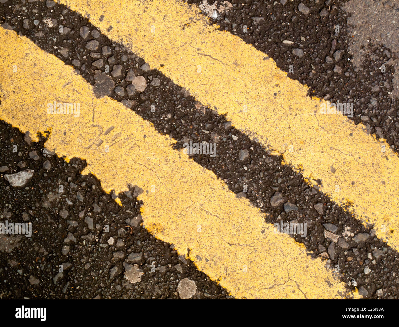 Double yellow lines painted on tarmac on a road in the UK to prevent