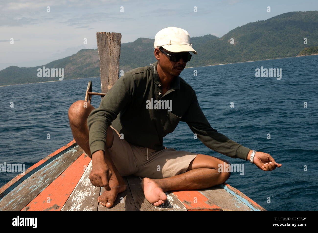 Man sitting on a Thai Long-Tail boat, Koh Lipe, Thailand Stock Photo
