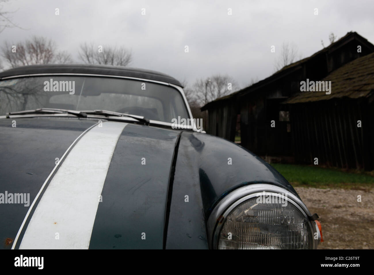 MG British Sportscar sits before auction sale next to a barn in rural Indiana. sports car MGB green racing stripe hood close up barn Stock Photo