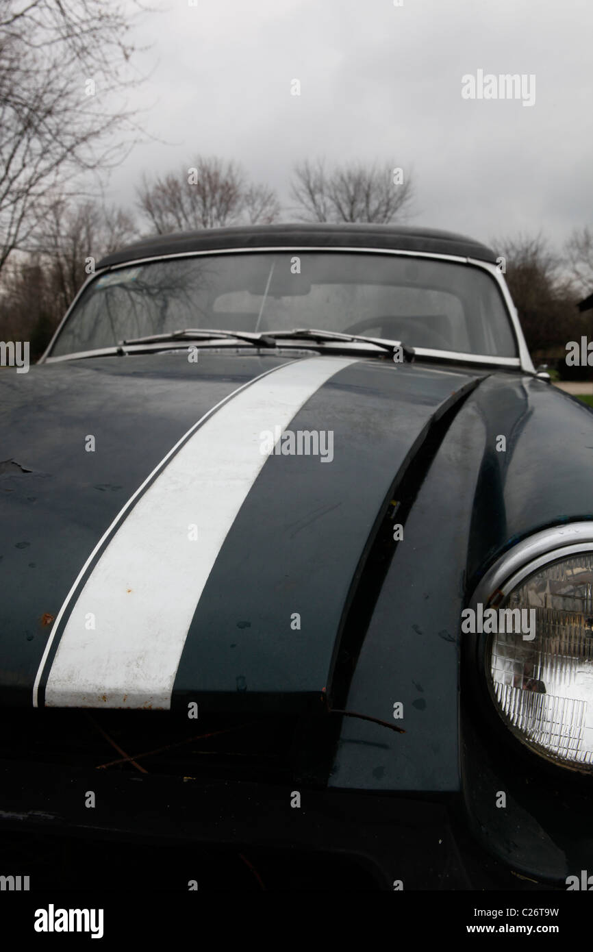 MG British Sportscar sits before auction sale next to a barn in rural Indiana. sports car MGB green racing stripe hood close up Stock Photo