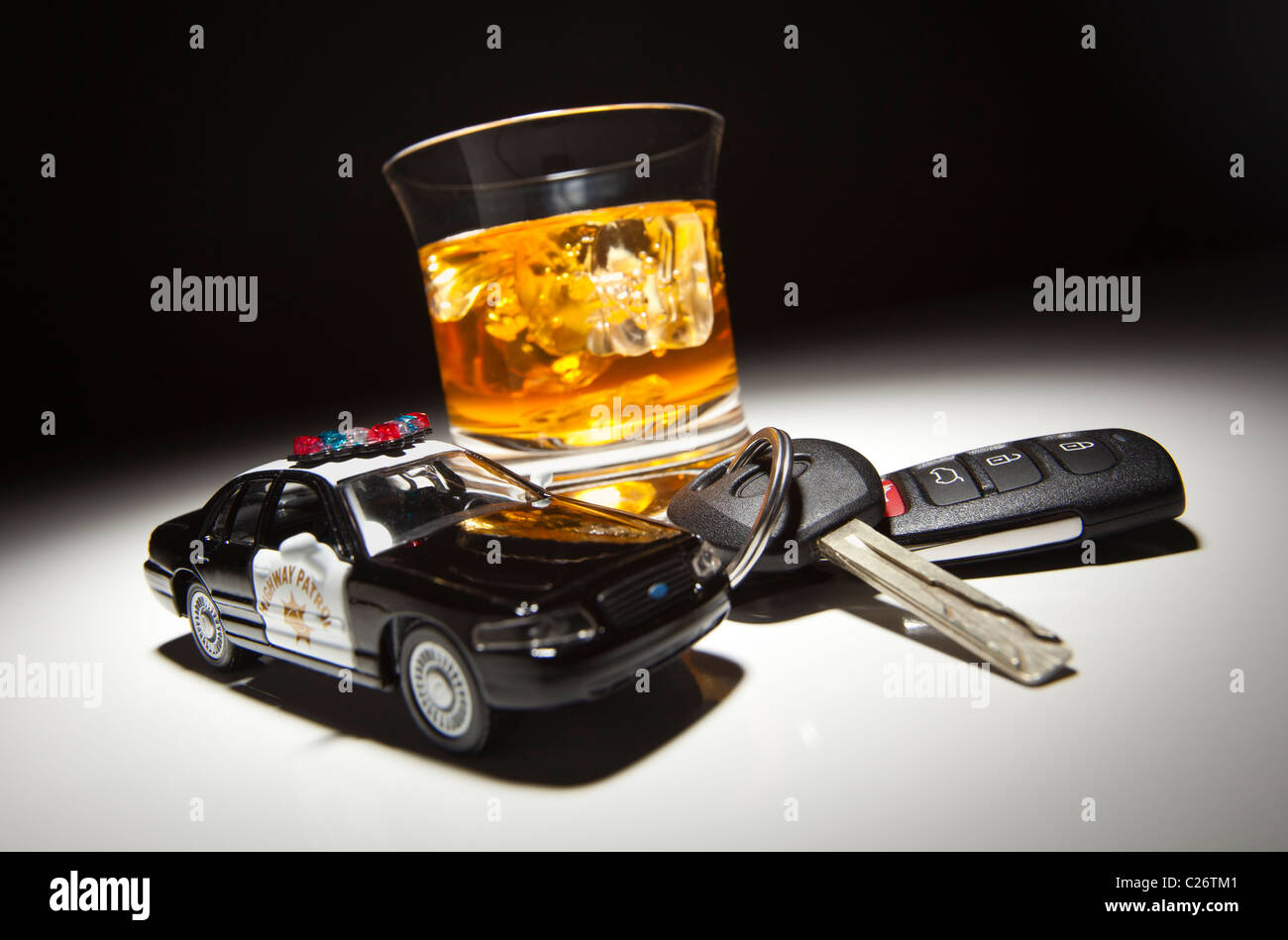 Highway Patrol Police Car Next to Alcoholic Drink and Keys Under Spot Light. Stock Photo