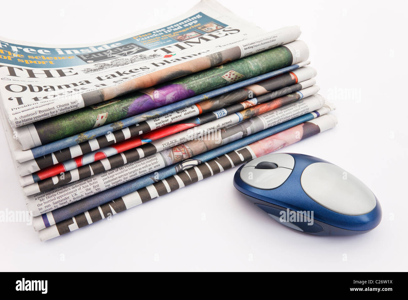 UK, Europe. Pile of newspapers with a computer mouse to represent the concept of changing future of the press on the Internet Stock Photo