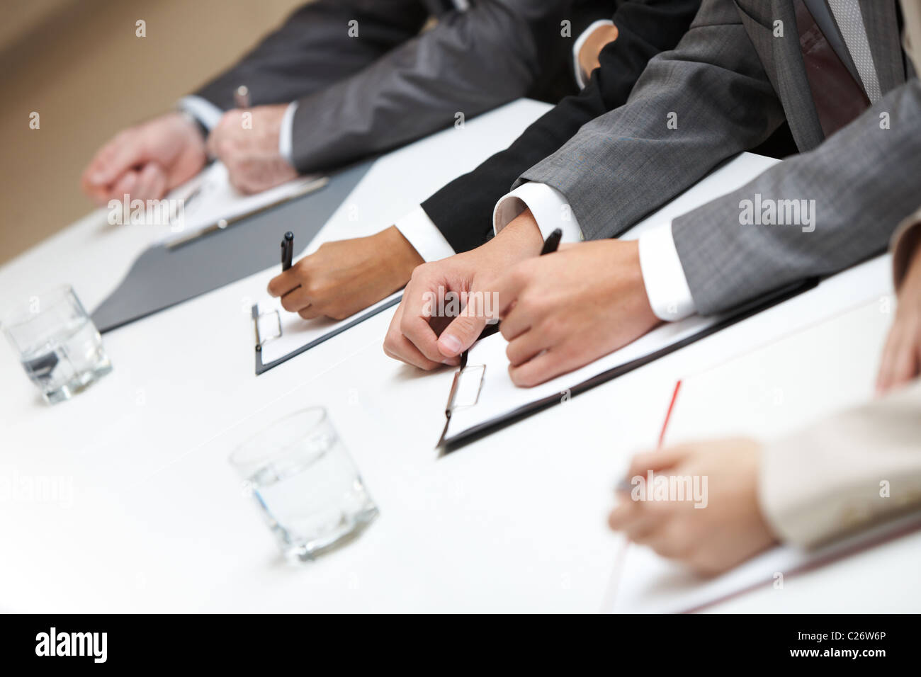 Row of hands making notes Stock Photo - Alamy