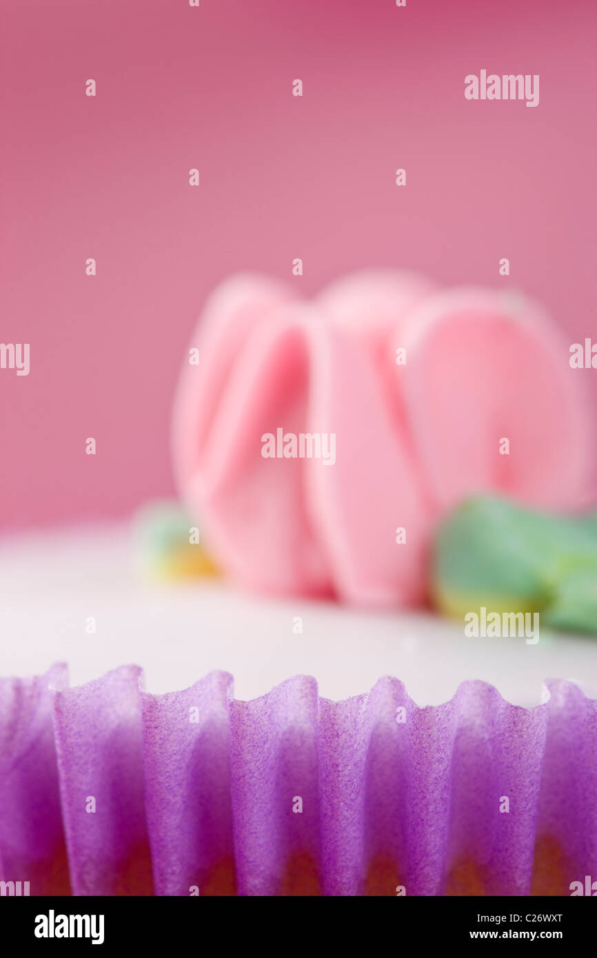 Purple Cupcake with Pastel Pink Flower Decoration Stock Photo