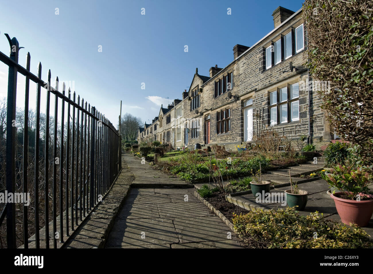 Stone built victorian housing with metal fencing on stone flags. Stock Photo