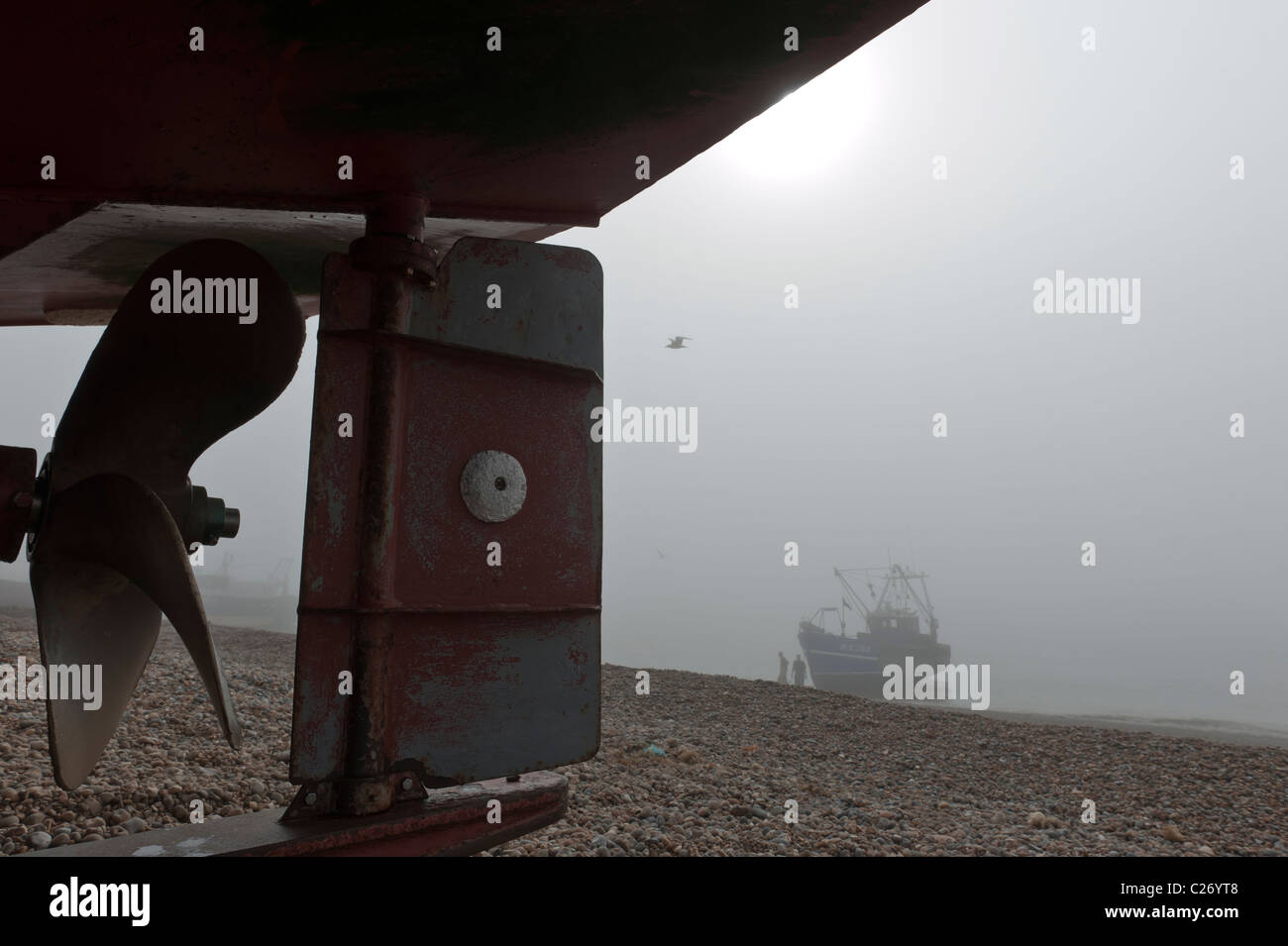 A fishing boat landing on the shingle beach on Hastings Stade East Sussex UK on a foggy day Stock Photo